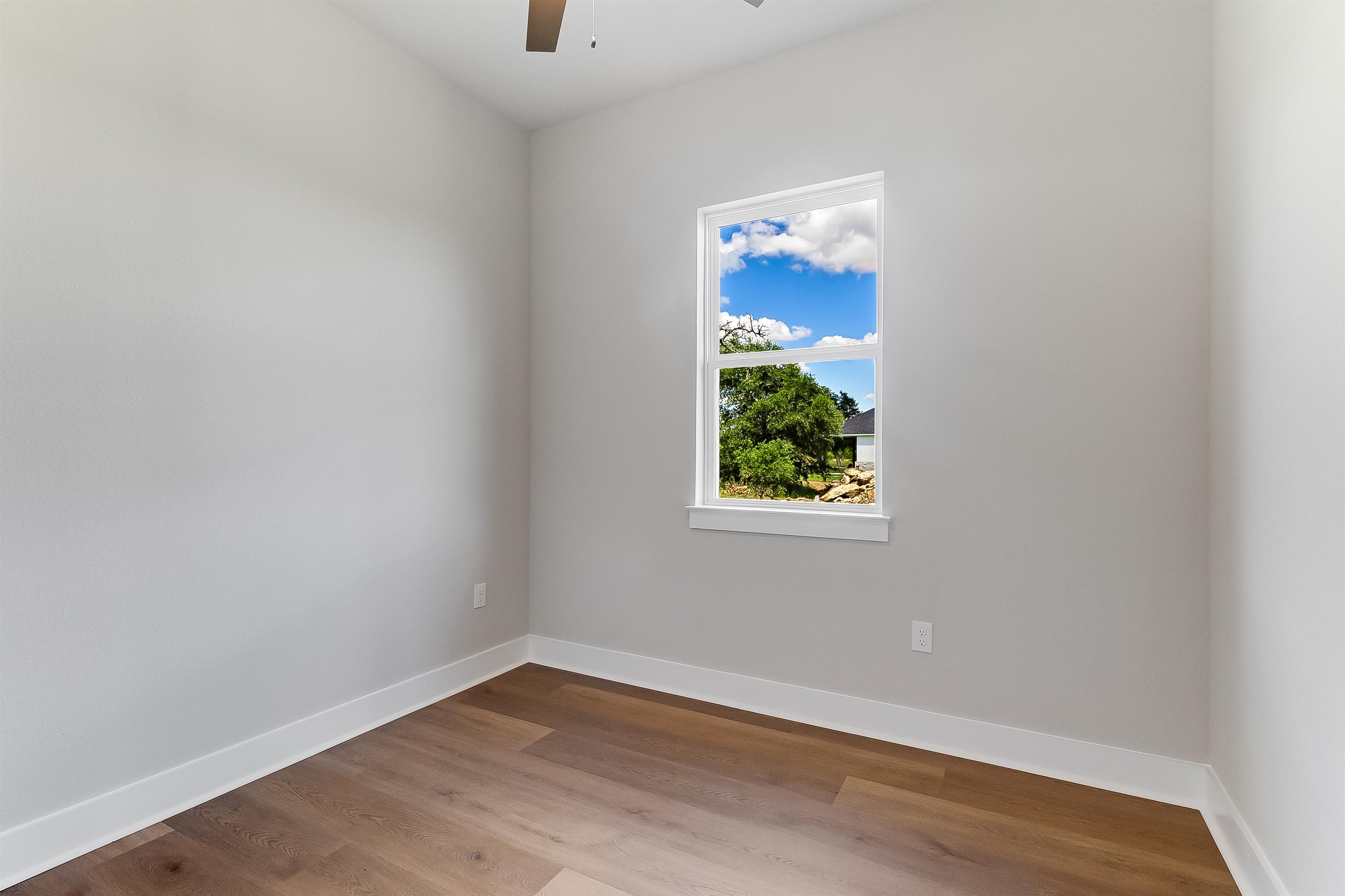 124 Draper Lane Bertram, TX 78605 - Photo 25 of 30 an empty room with wooden floor and windows