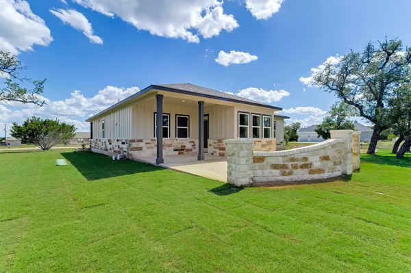 a view of house with garden and outdoor seating