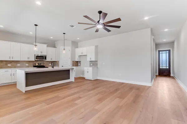 a view of kitchen with refrigerator and microwave