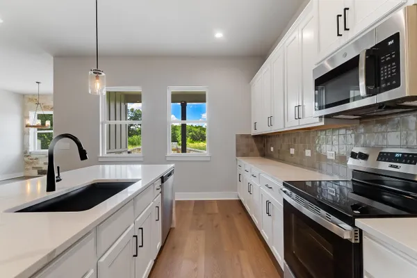 a kitchen with stainless steel appliances a sink a stove and microwave