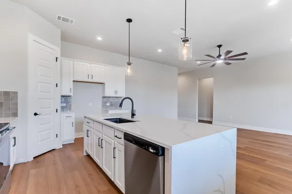 a kitchen with stainless steel appliances kitchen island a sink and a refrigerator