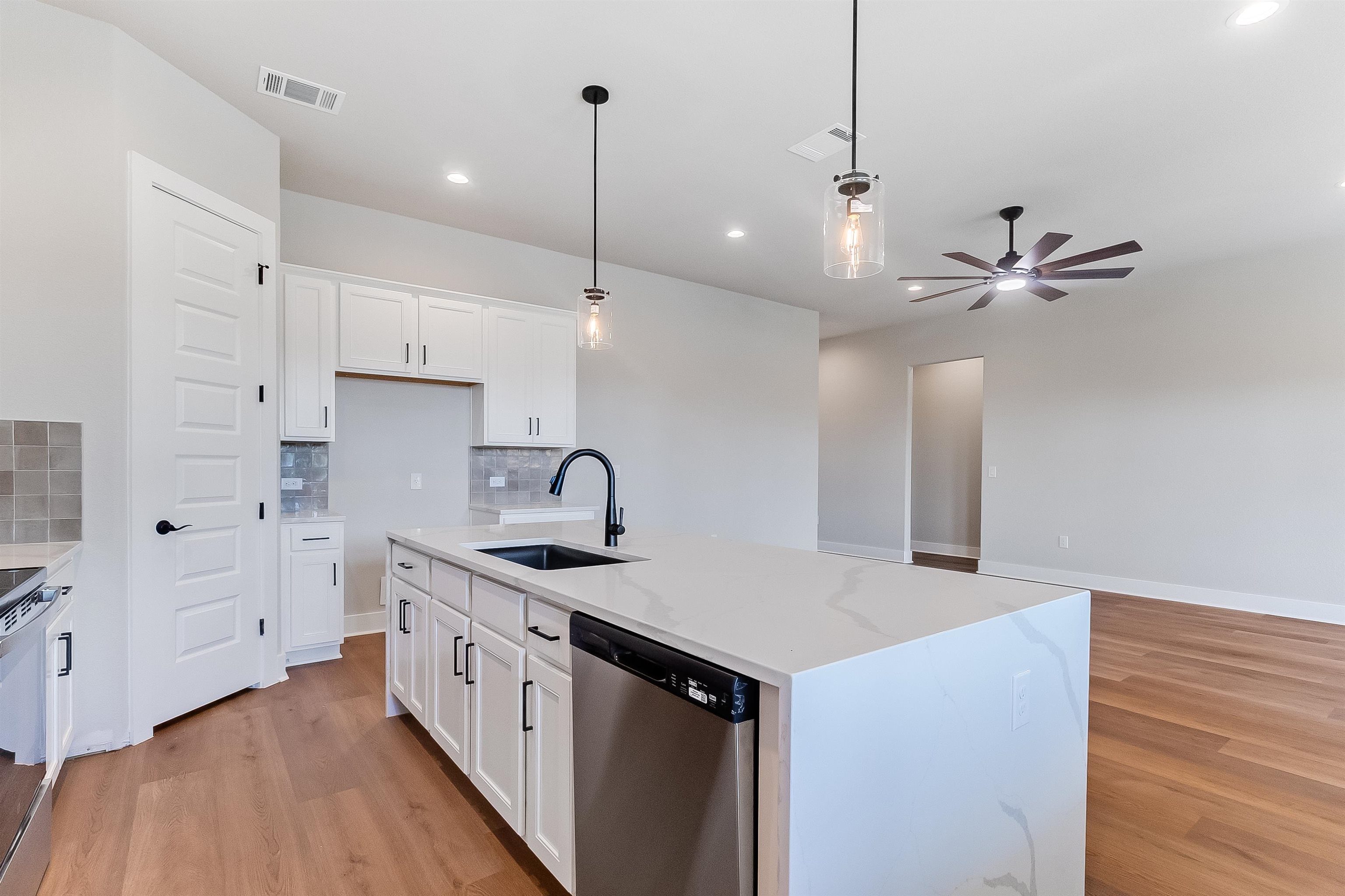124 Draper Lane Bertram, TX 78605 - Photo 10 of 30 a kitchen with stainless steel appliances kitchen island a sink and a refrigerator