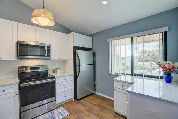 a kitchen with stainless steel appliances granite countertop a refrigerator and a stove top oven