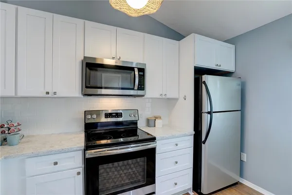 a kitchen with white cabinets and stainless steel appliances