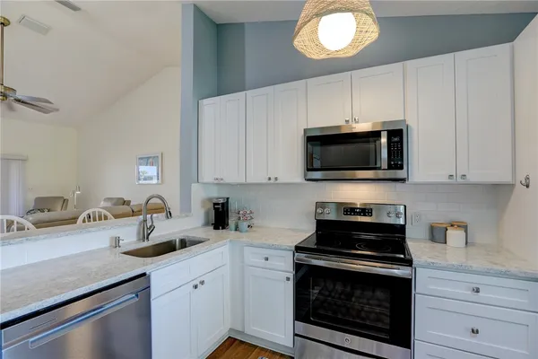 a kitchen with stainless steel appliances a stove a sink and a microwave