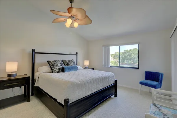 a bedroom with a bed chandelier and a window