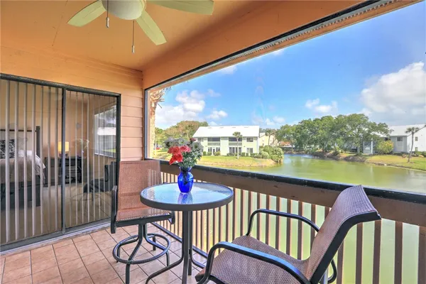 a view of a balcony with dining table and chairs