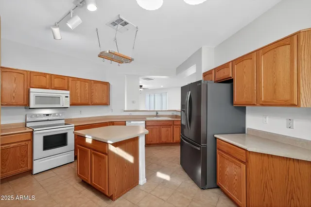a kitchen with stainless steel appliances granite countertop a sink and a refrigerator