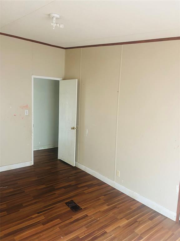 1100 Pecan Ridge Drive Venus, TX 76084 - Photo 8 of 13 Empty room with dark wood finished floors and ornamental molding
