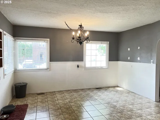 a view of a room with a chandelier fan and windows