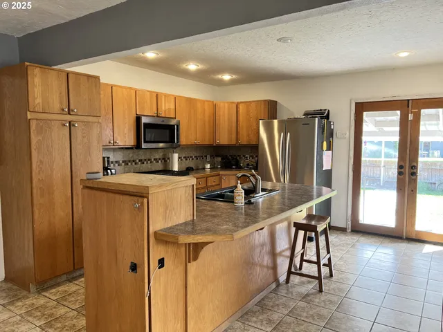 a kitchen with stainless steel appliances granite countertop a refrigerator stove microwave and sink