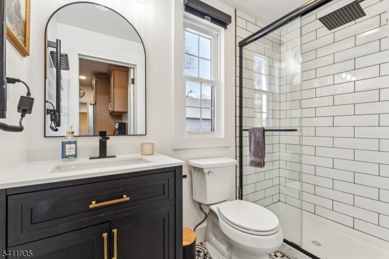64 Hillcrest Road Watchung, NJ 07069 - Photo 18 of 42 a bathroom with a toilet a sink a mirror a window and vanity