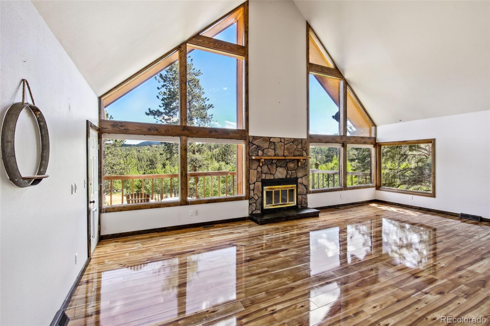 141 Tall Timber Lane Bailey, CO 80421 - Photo 12 of 40 a view of an empty room with a window and wooden floor