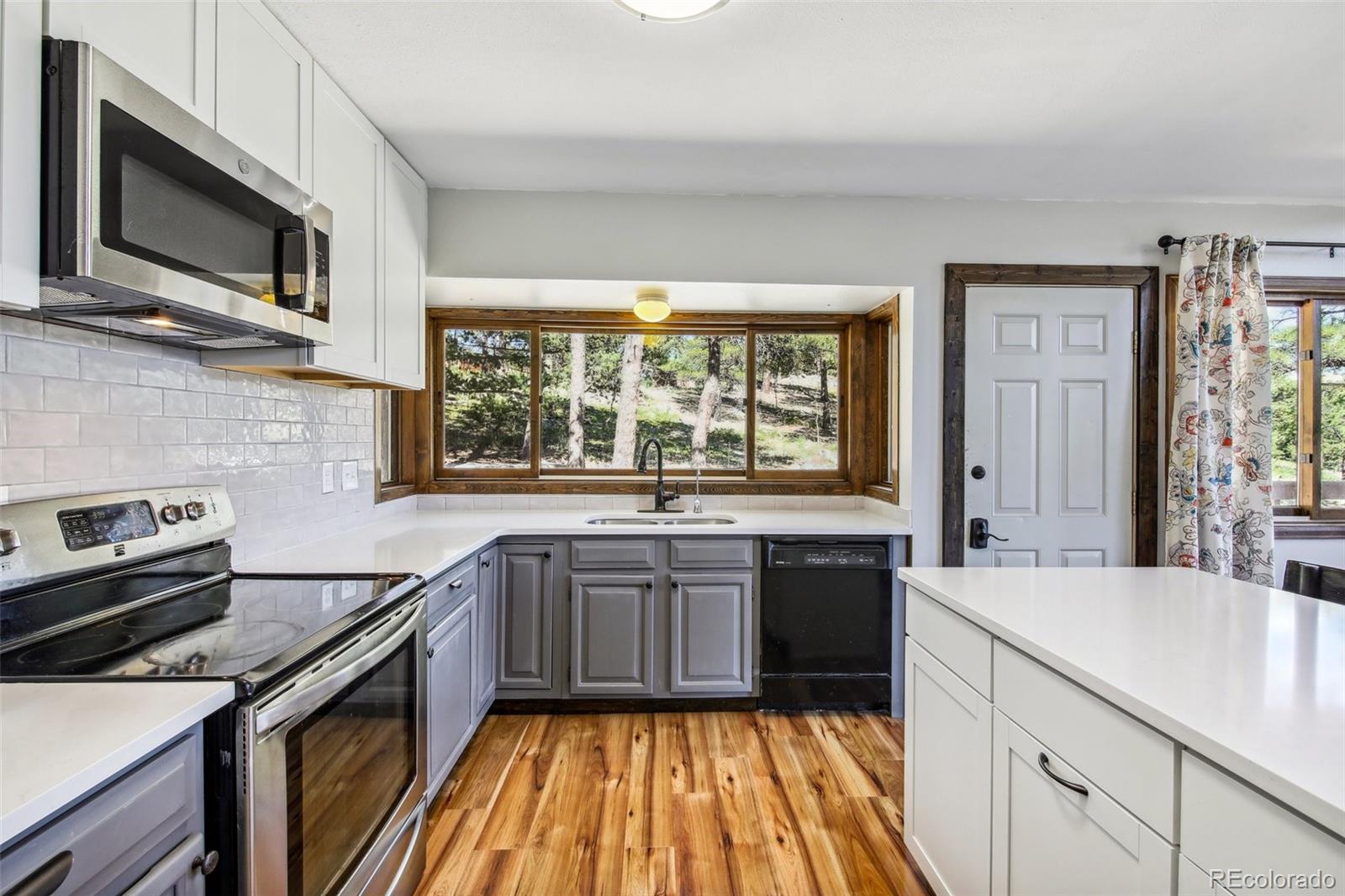 141 Tall Timber Lane Bailey, CO 80421 - Photo 17 of 40 a kitchen with a sink stove and microwave