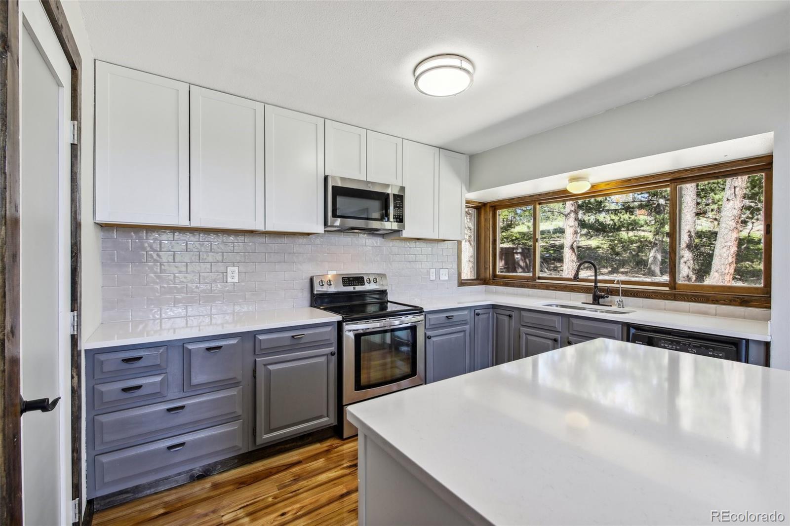 141 Tall Timber Lane Bailey, CO 80421 - Photo 18 of 40 a kitchen with a stove a sink and a microwave