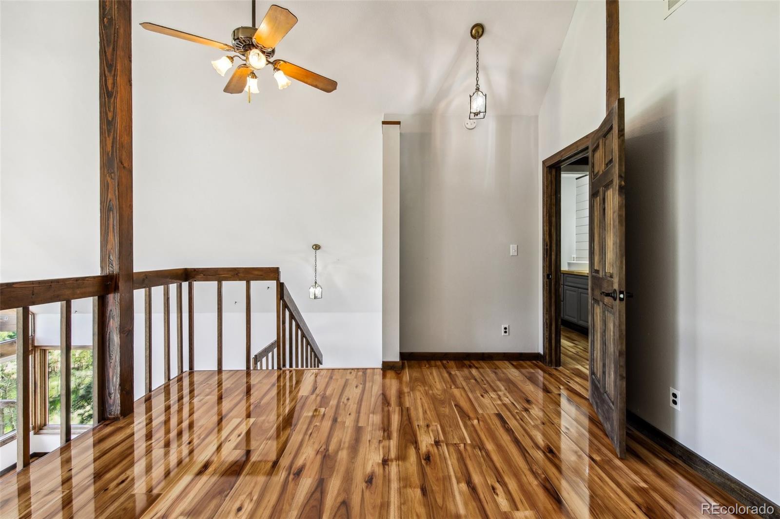 141 Tall Timber Lane Bailey, CO 80421 - Photo 21 of 40 a view of a hallway with wooden floor and a ceiling fan