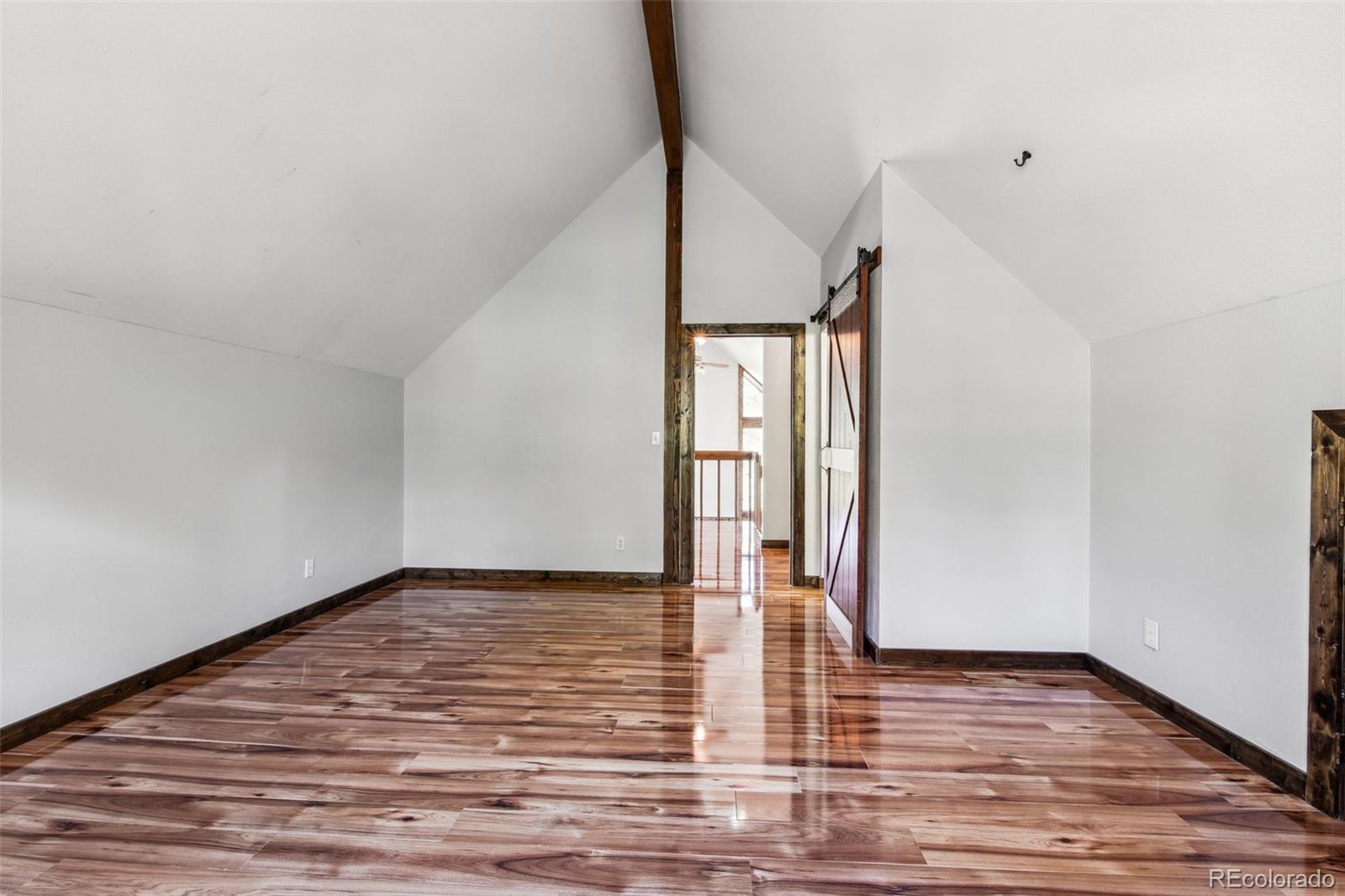 141 Tall Timber Lane Bailey, CO 80421 - Photo 28 of 40 a view of empty room with wooden floor and fan
