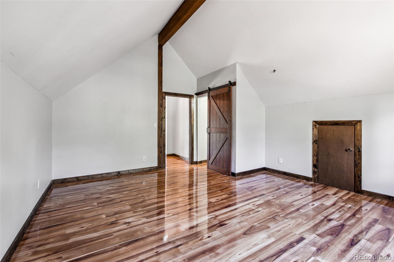 141 Tall Timber Lane Bailey, CO 80421 - Photo 29 of 40 a view of an empty room with wooden floor and a window