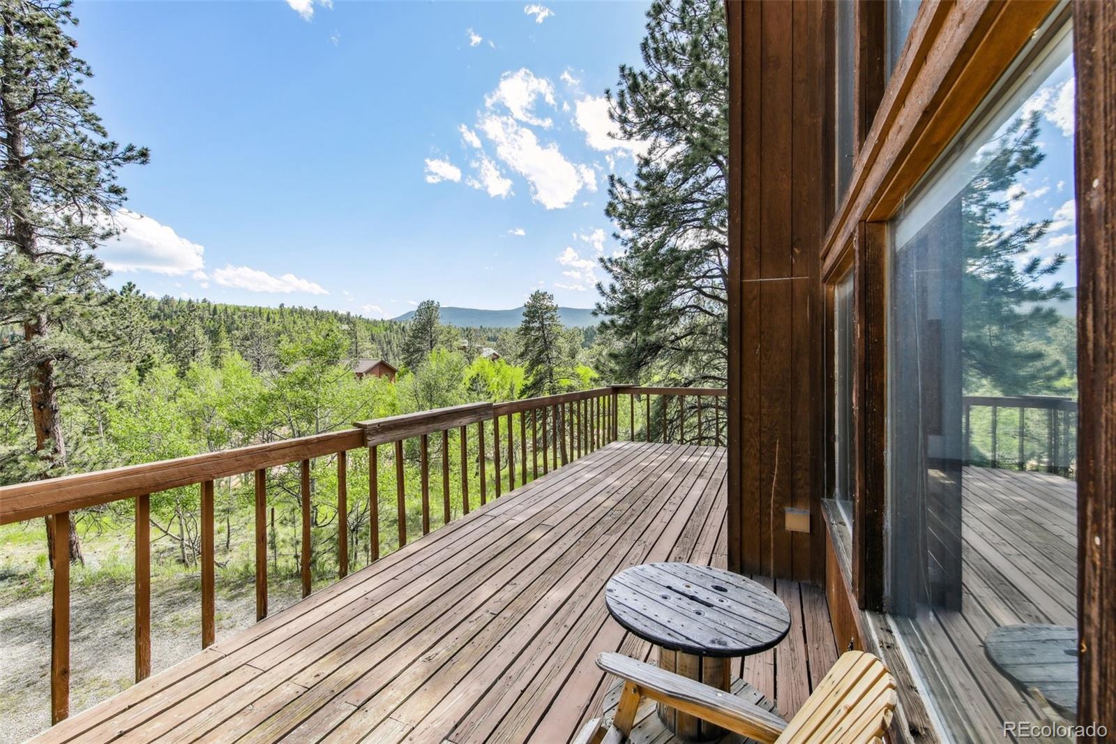 141 Tall Timber Lane Bailey, CO 80421 - Photo 9 of 40 a view of a balcony with mountain view and wooden floor