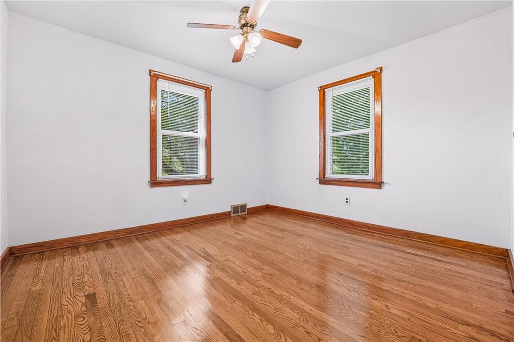 105 Williamson Road Greenville, PA 16125 - Photo 18 of 27 an empty room with wooden floor ceiling fan and windows