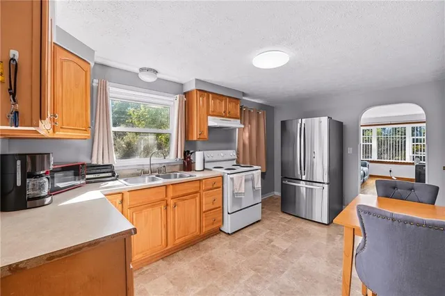 a kitchen with stainless steel appliances granite countertop a refrigerator and a sink