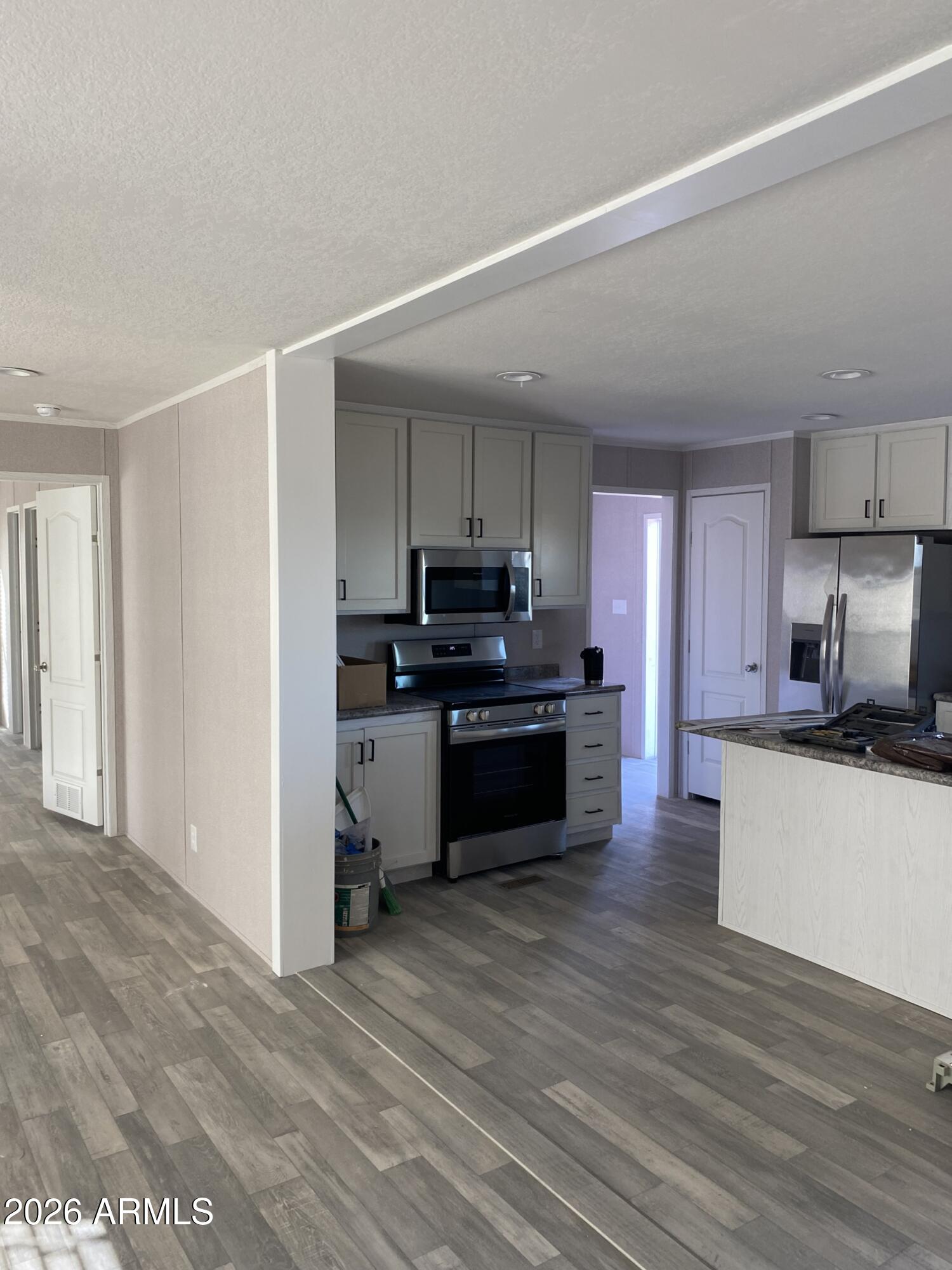 519 South Ortega Road Stanfield, AZ 85172 - Photo 16 of 29 a kitchen with granite countertop a stove top oven and cabinets