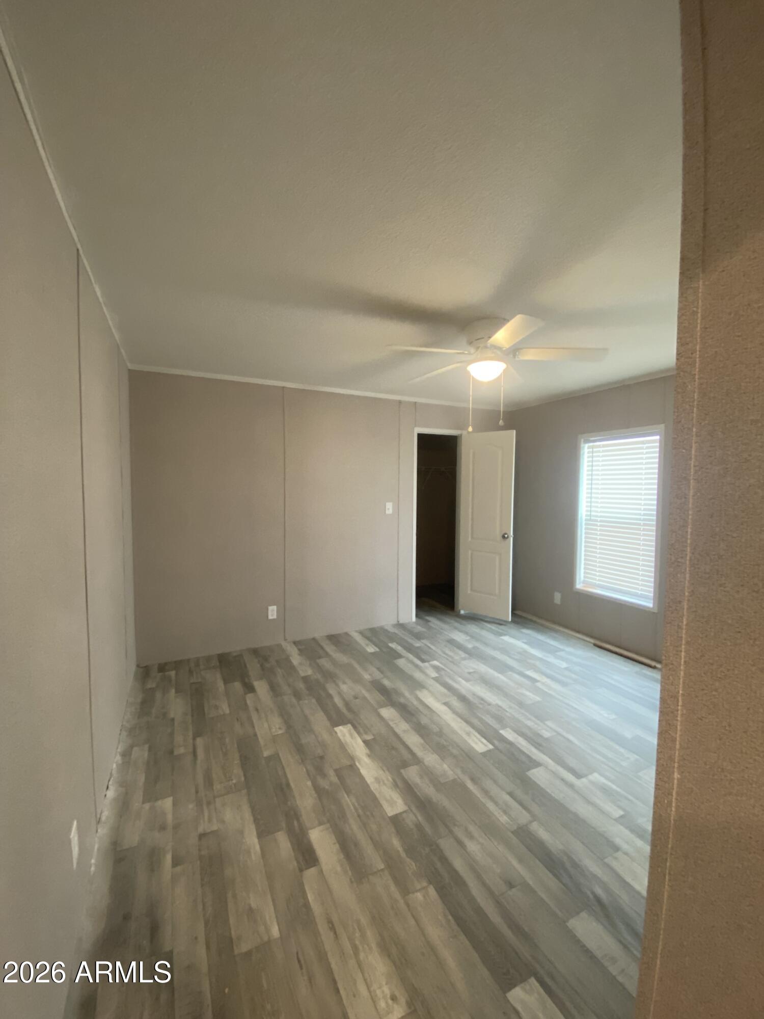 519 South Ortega Road Stanfield, AZ 85172 - Photo 26 of 29 a view of an empty room with window and wooden floor