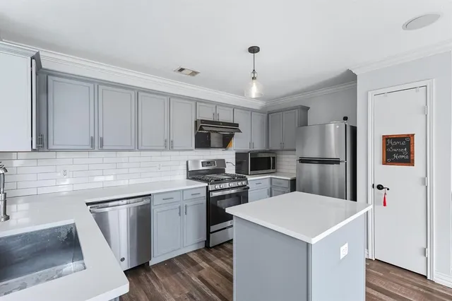 a kitchen with a sink a refrigerator a microwave and cabinets