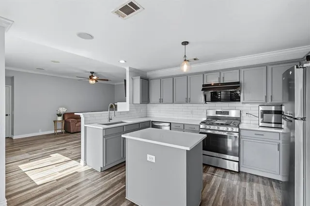 a kitchen with a sink a stove and cabinets