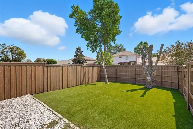 a view of a backyard with a wooden fence