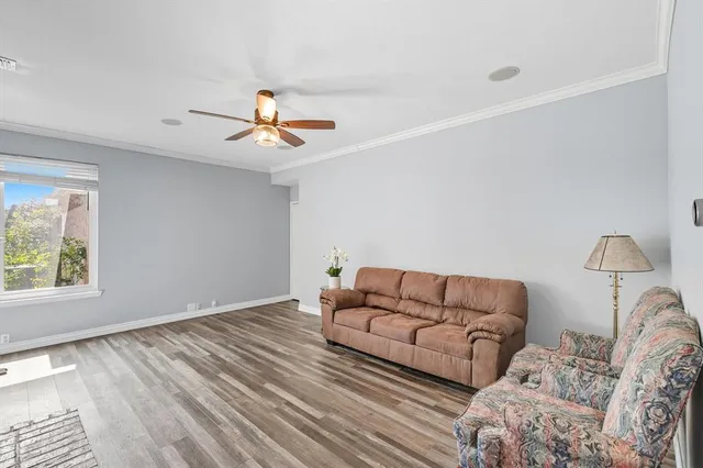 a living room with furniture and a ceiling fan