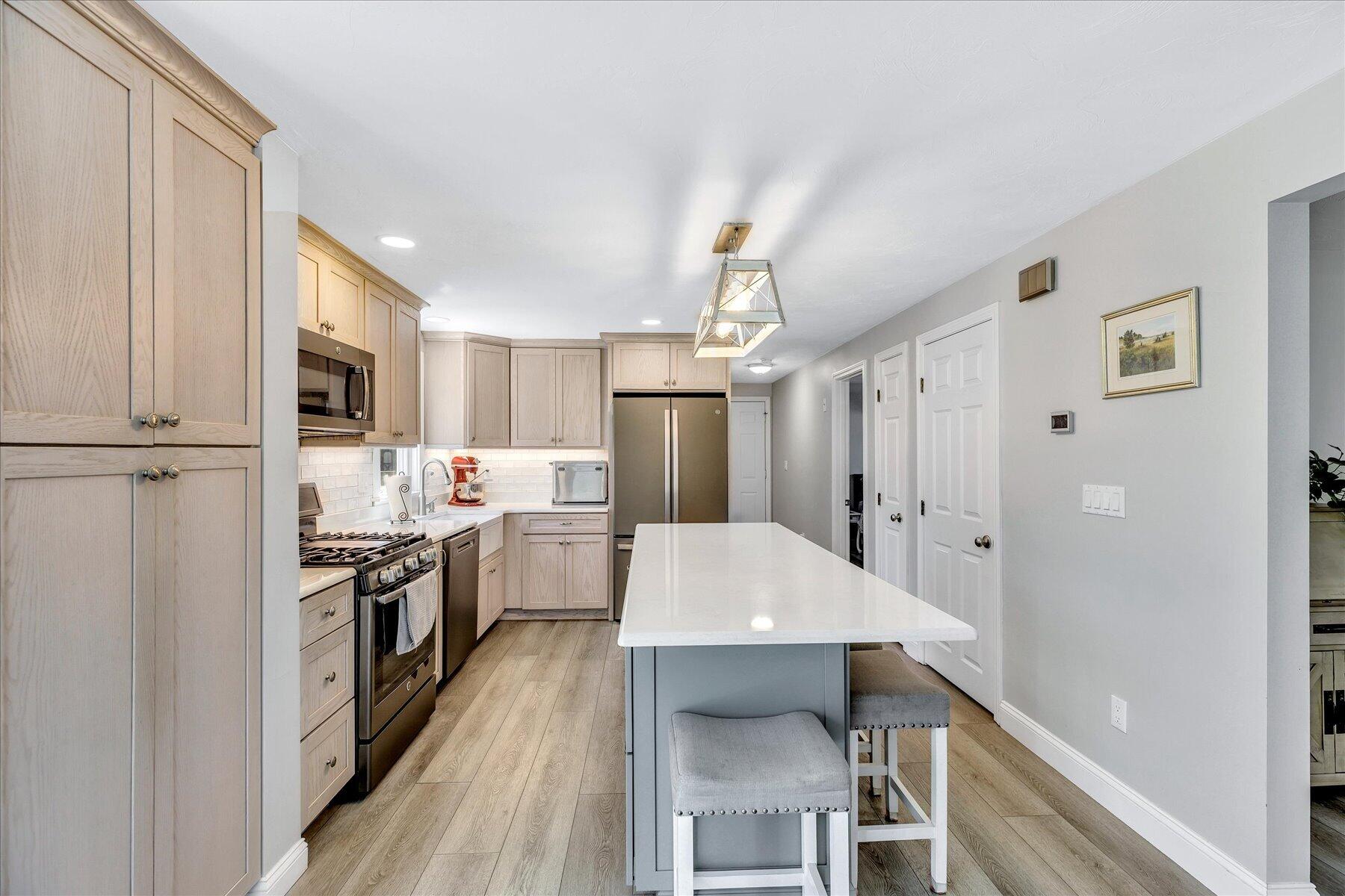 12 Drew Lane Mashpee, MA 02649 - Photo 14 of 49 a kitchen with stainless steel appliances a stove top oven a sink a refrigerator white cabinets and wooden floor