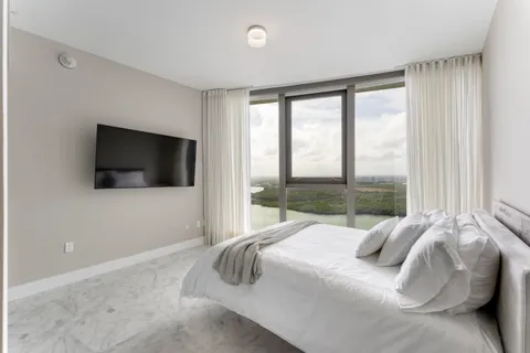 a large bedroom with a bed and a flat screen tv