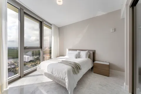 a bedroom with a bed and large window