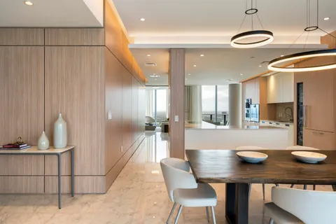 a kitchen with stainless steel appliances kitchen island granite countertop a table chairs and a refrigerator