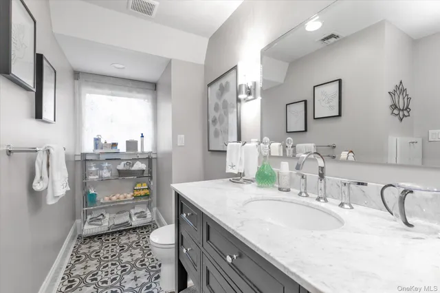 a bathroom with a granite countertop sink a toilet and a tub