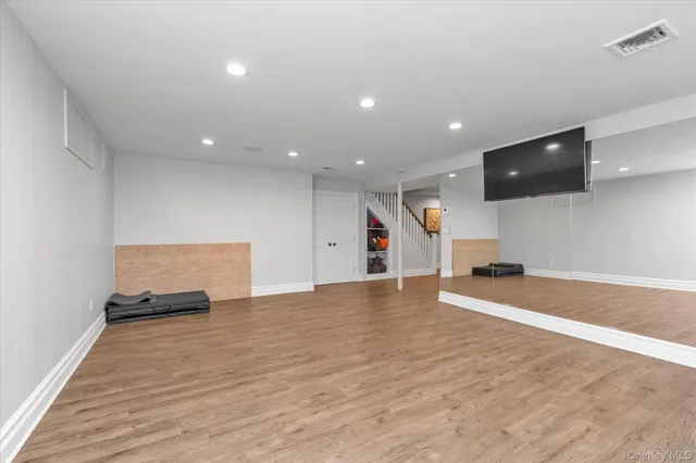 a view of empty room with wooden floor and flat screen tv