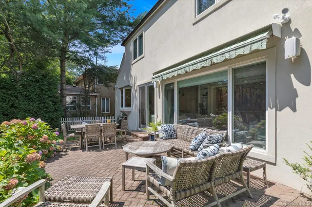 a view of a patio with couches table and chairs and potted plants