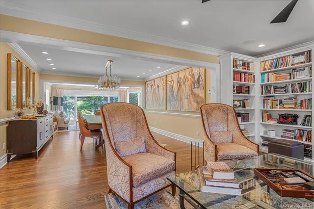 a living room with furniture a piano and a bookshelf