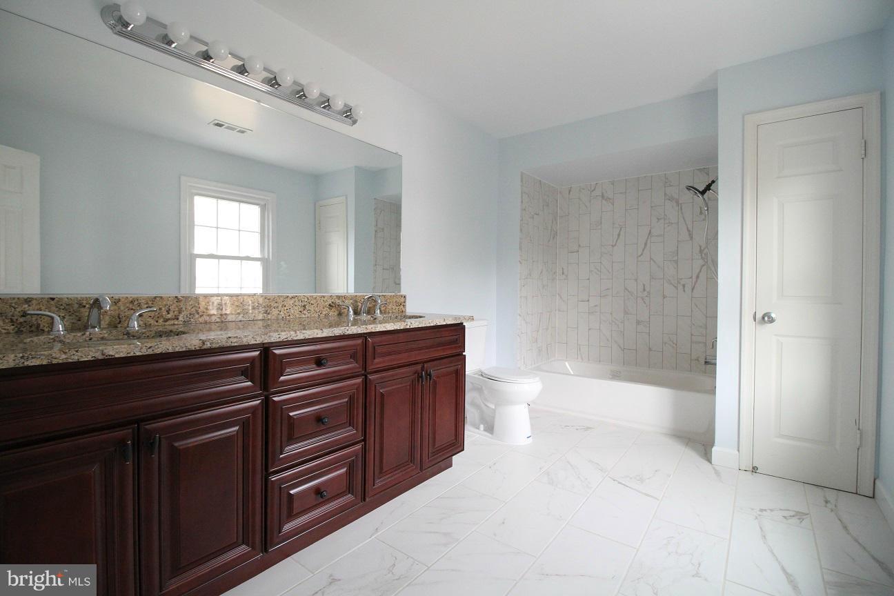 2646 Wild Cherry Place Reston, VA 20191 - Photo 14 of 26 a bathroom with a granite countertop double vanity sink mirror and toilet