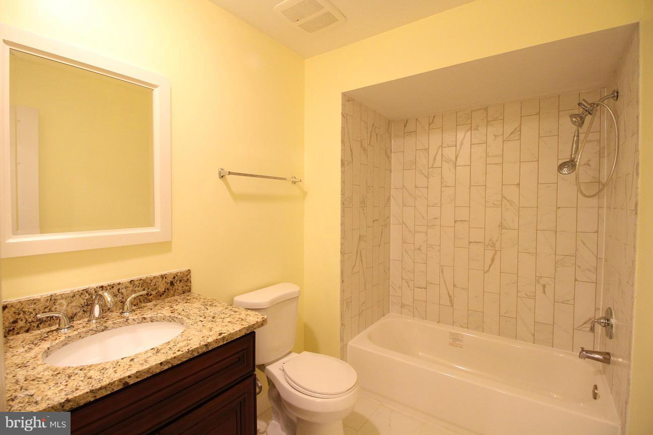 2646 Wild Cherry Place Reston, VA 20191 - Photo 20 of 26 a bathroom with a granite countertop sink toilet and shower