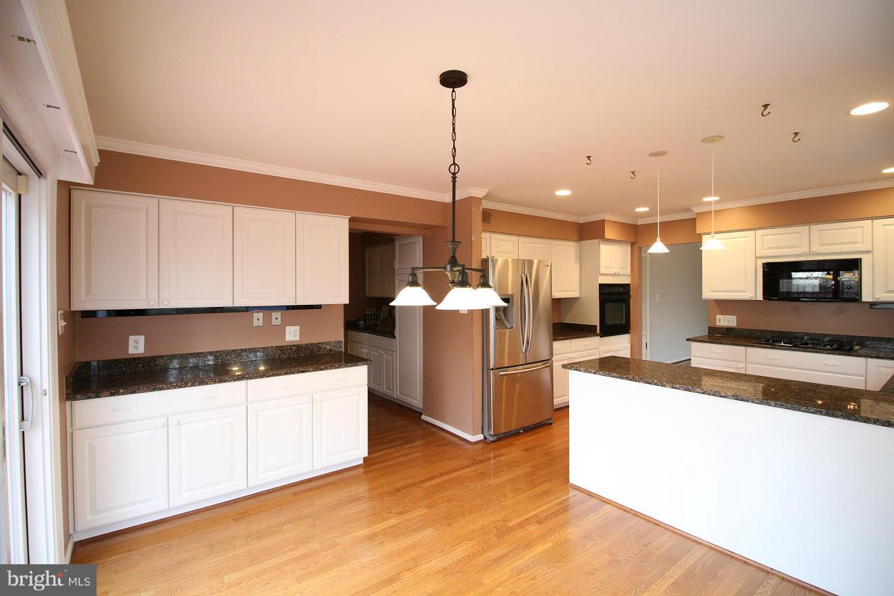 2646 Wild Cherry Place Reston, VA 20191 - Photo 6 of 26 a kitchen with stainless steel appliances kitchen island granite countertop a stove and a sink