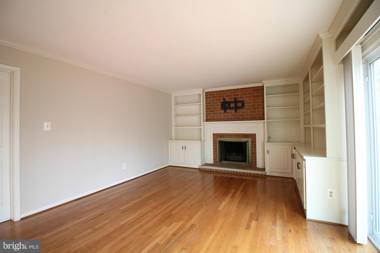 2646 Wild Cherry Place Reston, VA 20191 - Photo 8 of 26 an empty room with wooden floor and fireplace