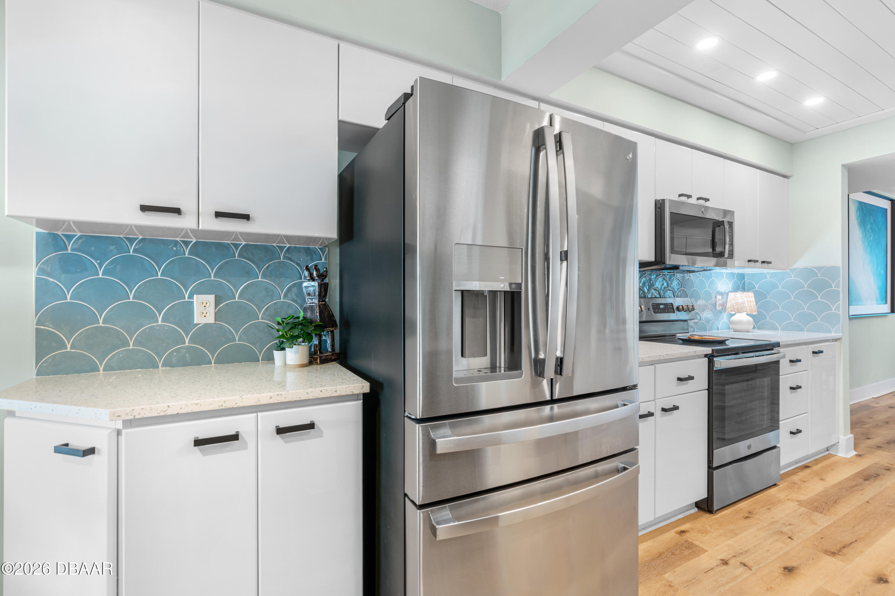 4565 South Atlantic Avenue, Unit 5410 Ponce Inlet, FL 32127 - Photo 19 of 67 a kitchen with stainless steel appliances white cabinets and wooden floor
