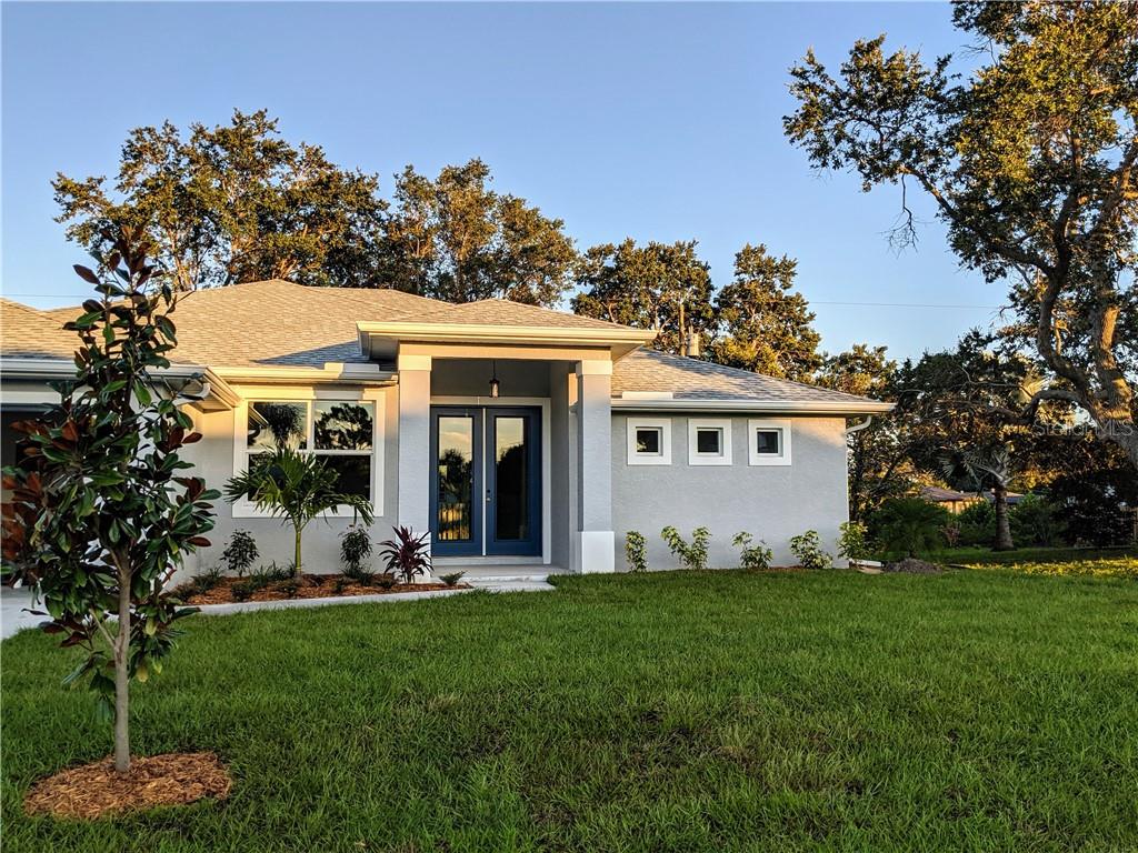621 Cabana Road Venice, FL 34293 - Photo 1 of 1 a view of a white house with a big yard and potted plants