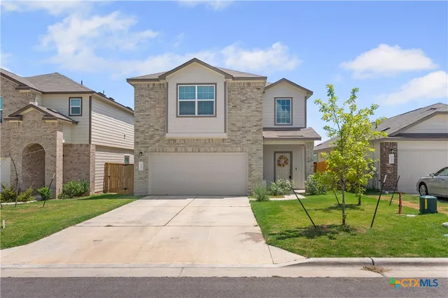a front view of a house with a garden and yard