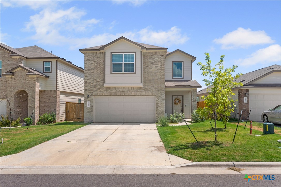 a front view of a house with a garden and yard
