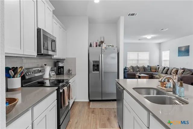 a kitchen that has a sink cabinets counter space stainless steel appliances and cabinets