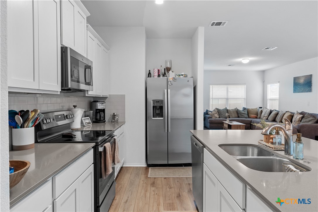 129 Rowdy Yates Way Jarrell, TX 76537 - Photo 11 of 41 a kitchen that has a sink cabinets counter space stainless steel appliances and cabinets