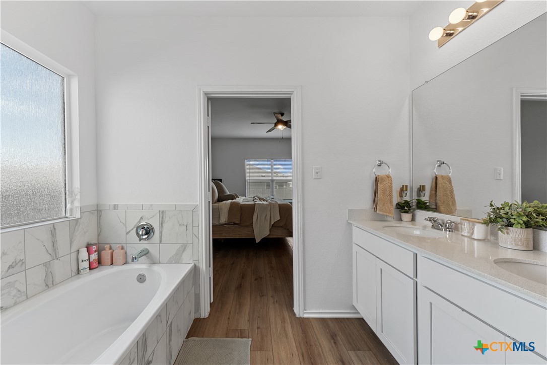129 Rowdy Yates Way Jarrell, TX 76537 - Photo 21 of 41 a en suite spacious bathroom with a tub double vanity and view bedroom